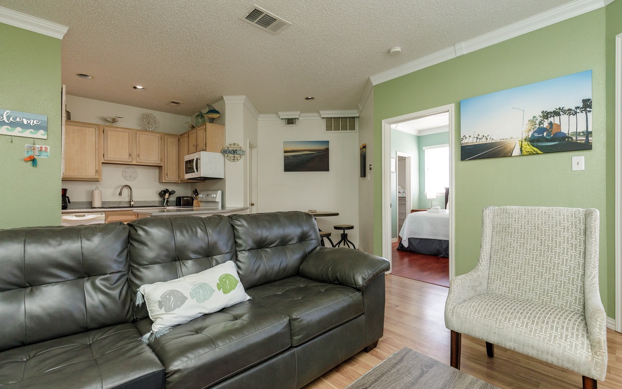 Relax in your bright open-concept living space with comfortable seating, fully equipped kitchen, and tasteful coastal decor throughout.
