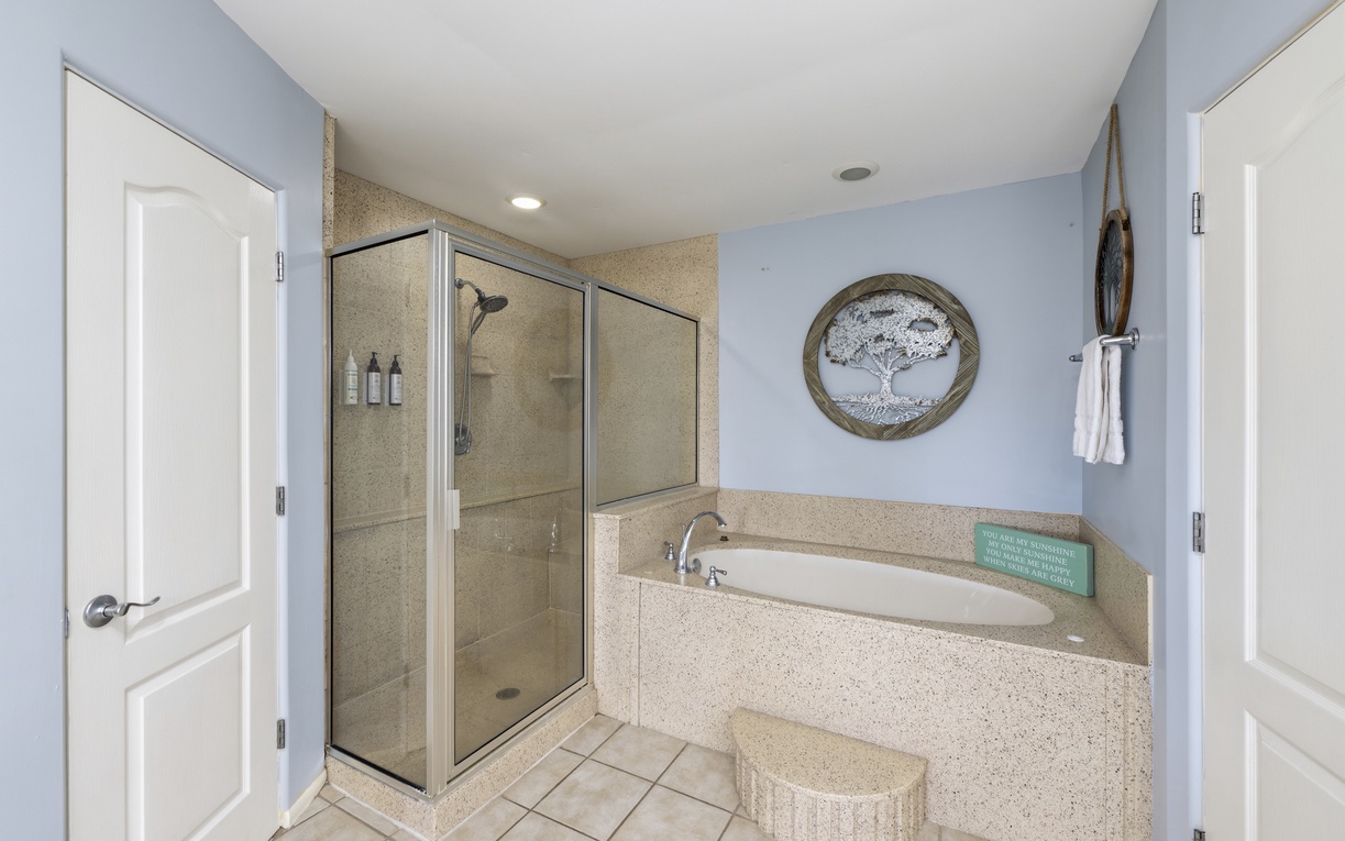 Unwind in your private retreat featuring tub (no Jacuzzi jets) and walk-in shower, where soft blue walls create a tranquil atmosphere.