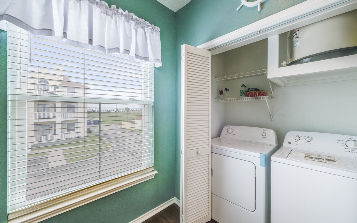 Enjoy the convenience of your own in-unit washer and dryer, tucked neatly into a cheerful coastal-themed space with natural light streaming in.