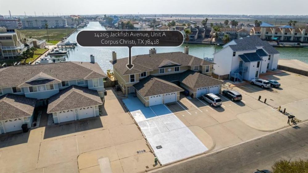 Aerial view of waterfront townhome with driveway parking and boat slip availability.