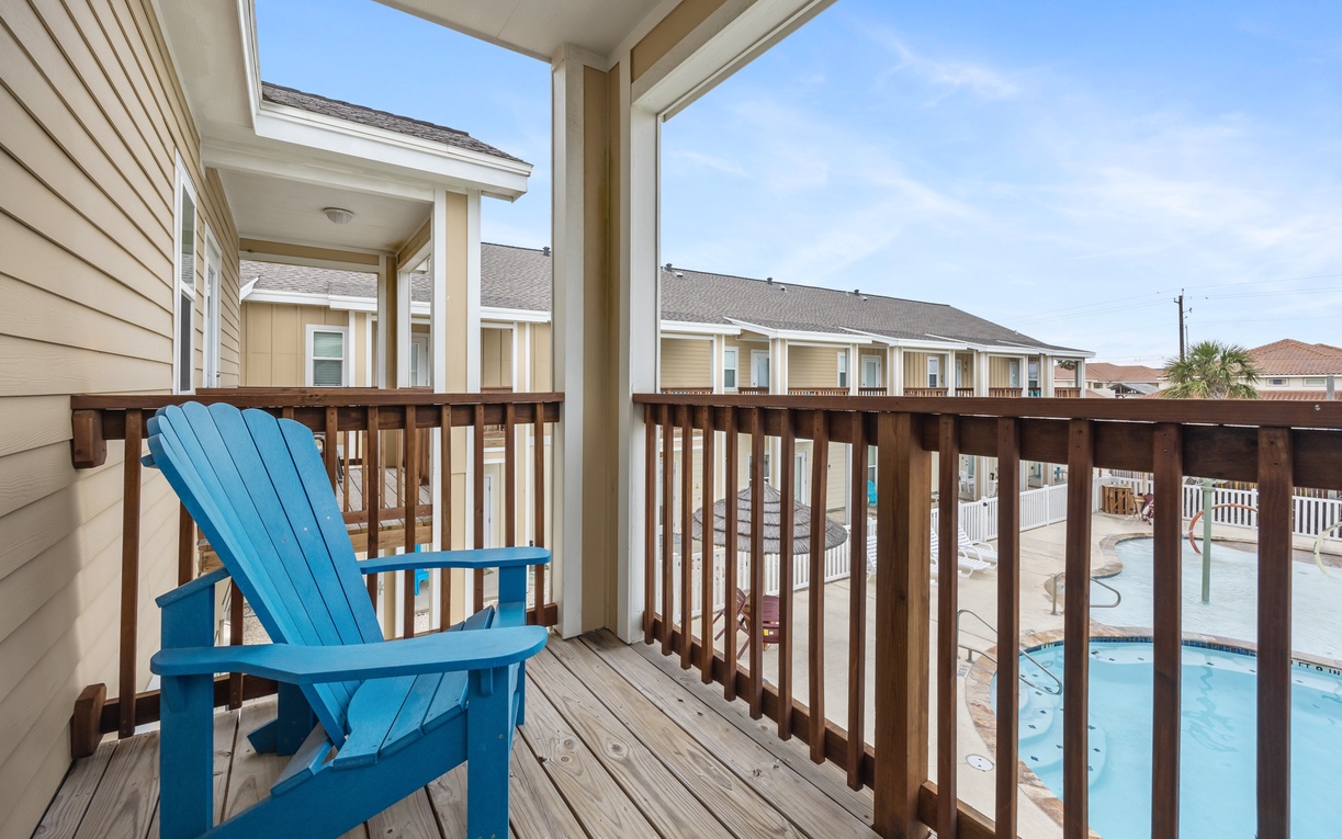 Relax in your bright blue Adirondack chair and soak up poolside views from this sunny private balcony.