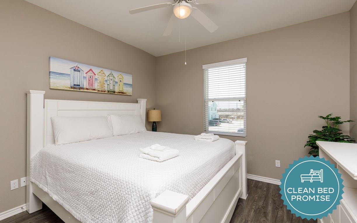 Your peaceful retreat features crisp white linens, coastal artwork, and gentle ceiling fan breezes for perfect comfort.