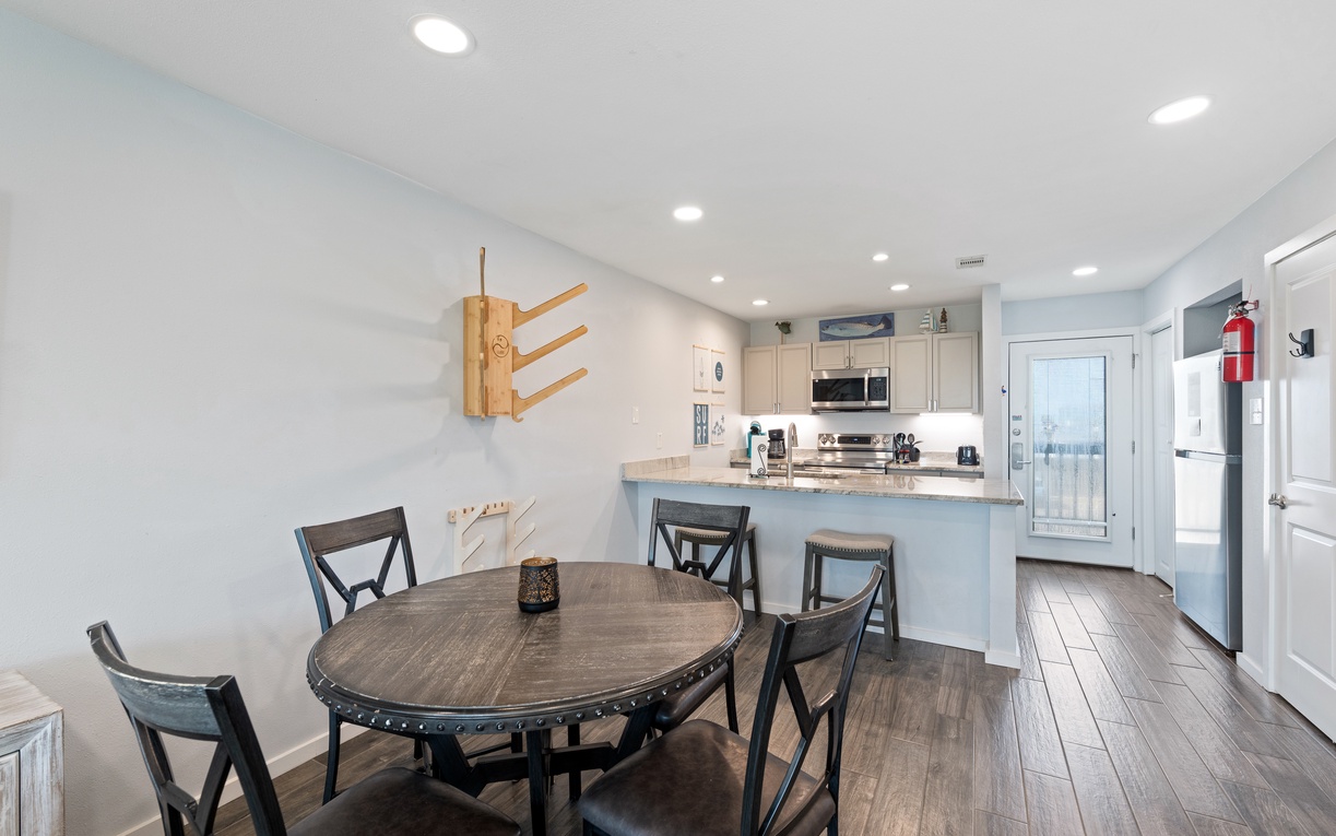 Step into your bright, open-plan dining and kitchen space where gathering for meals feels effortless. The breakfast bar invites leisurely mornings with coffee, while the full kitchen awaits your culinary creativity.