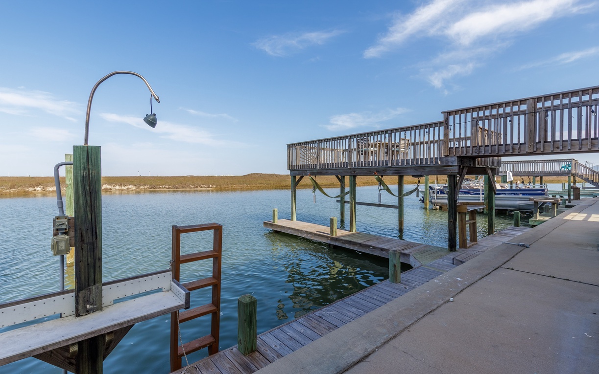 Waterfront dock facilities provide easy lake access with boat slips and fishing stations beneath blue skies.