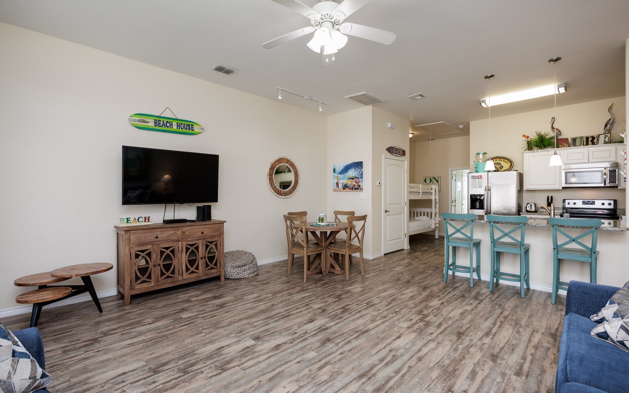 Your beach-themed retreat features an open living space with turquoise bar stools and coastal charm throughout every detail.