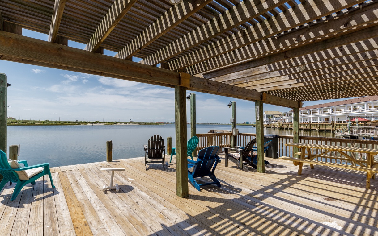Relax in colorful Adirondack chairs on your private waterfront deck, where filtered sunlight and gentle bay breezes create the perfect retreat.