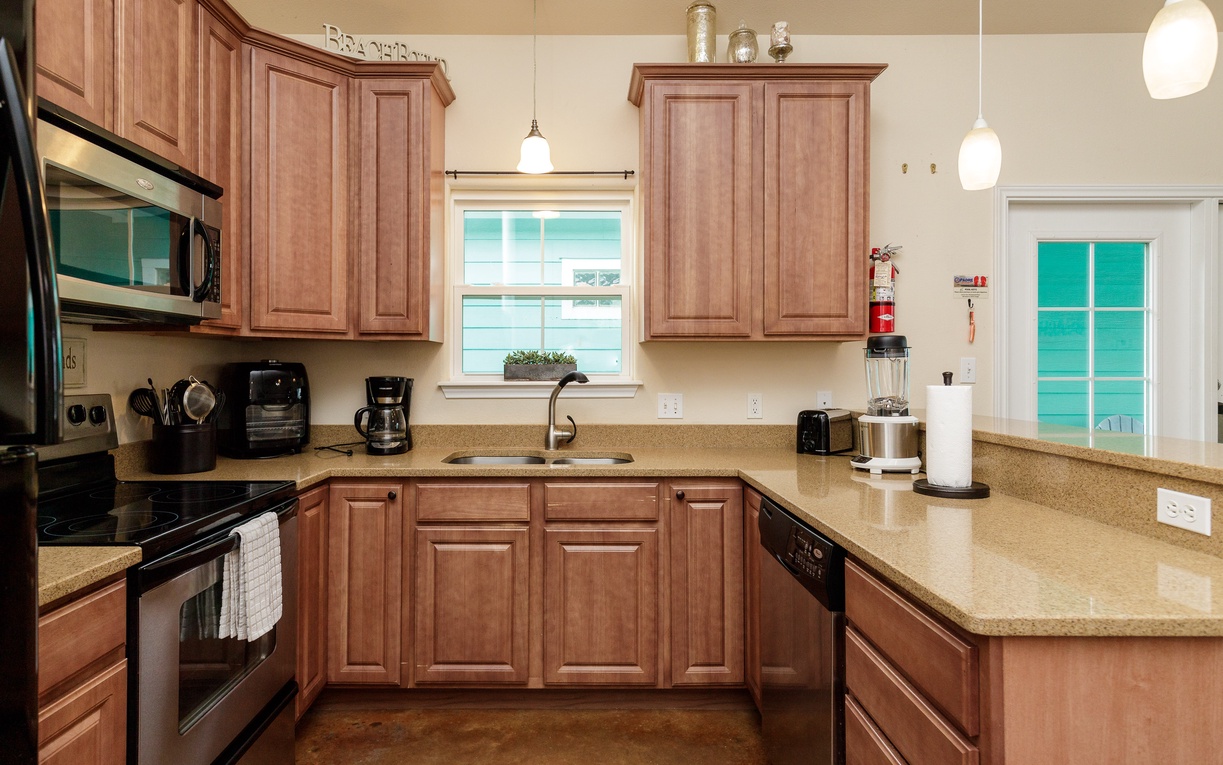Your fully equipped kitchen features warm wood cabinetry, granite countertops, and modern appliances, creating the perfect space for preparing meals.