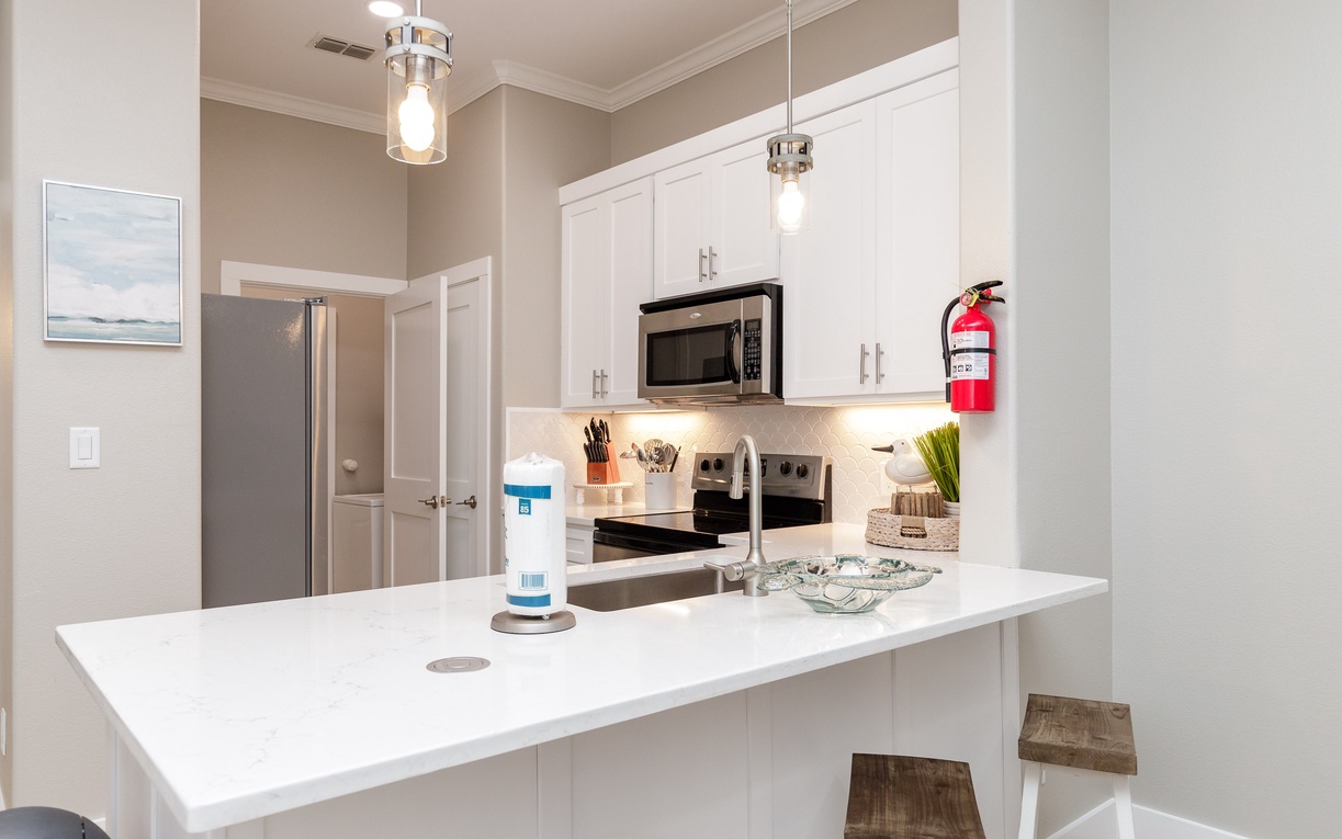 Your fully equipped kitchen features modern appliances and elegant white countertops, perfect for preparing meals during your stay.