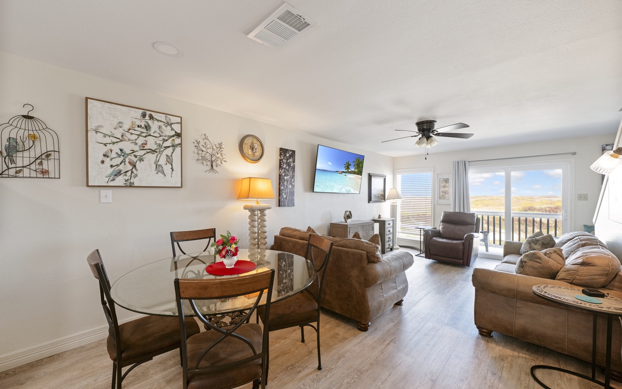 Relax in your spacious living area with comfortable seating, dining space, and stunning views from your private balcony overlooking golden fields.