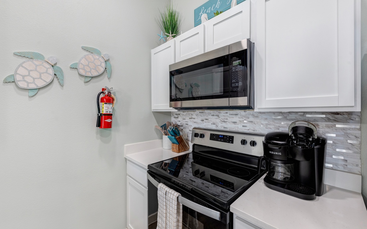 Your fully equipped kitchen awaits with modern appliances and coastal charm—perfect for brewing morning coffee or preparing fresh meals.
