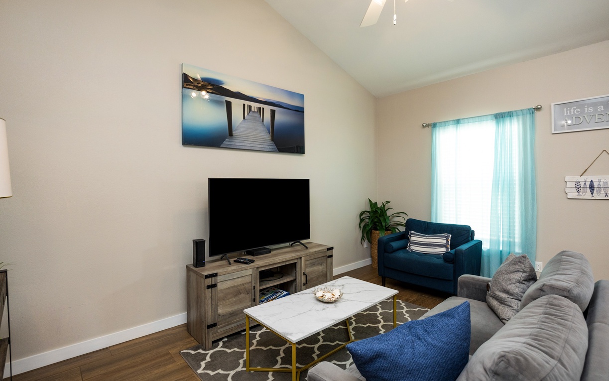 Sink into plush seating and unwind with your favorite shows in this bright, coastal-inspired living room designed for comfort.