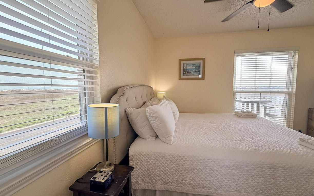 Your comfortable bedroom features a plush bed and expansive windows where natural light streams through, creating a peaceful retreat for restful nights.