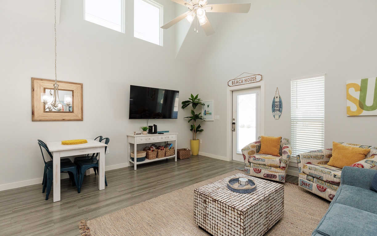 Relax in your bright, beach-themed living space with comfortable seating, modern TV, and cheerful coastal décor that makes every moment feel like vacation.