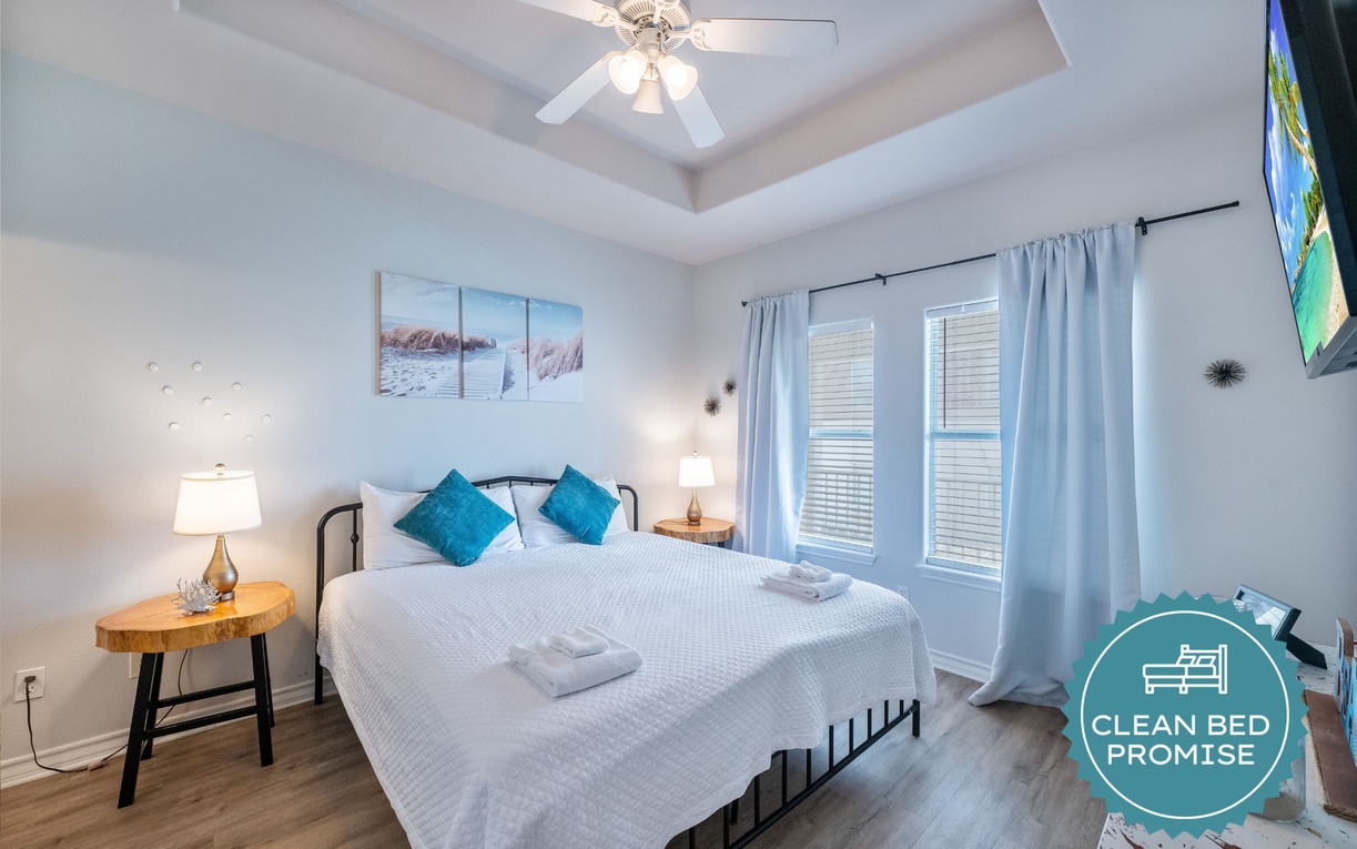 Your serene bedroom features crisp linens, coastal artwork, and soothing teal accents. Relax under the ceiling fan's gentle breeze.