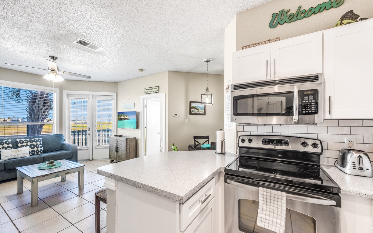 Your bright, open kitchen flows seamlessly into the living area, perfect for cooking meals while socializing on vacation.