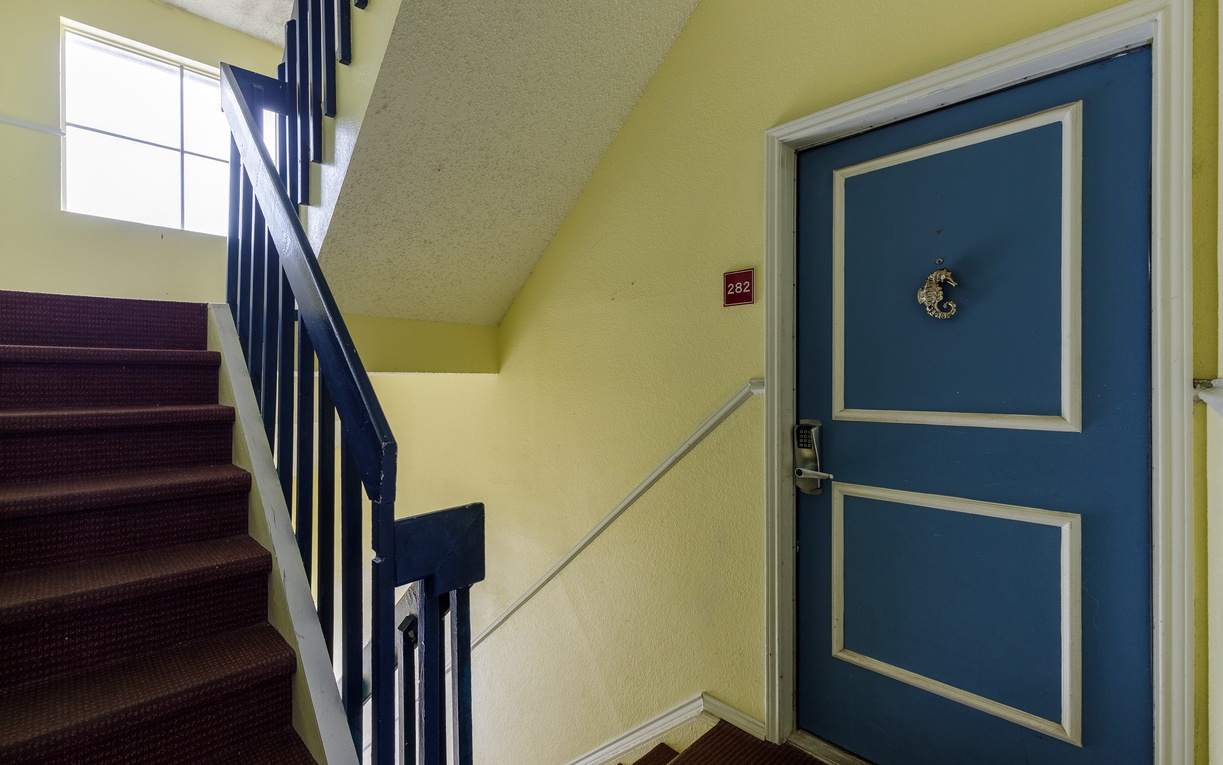Your charming blue door awaits with classic details and a festive wreath, creating an inviting entrance to your home away from home.