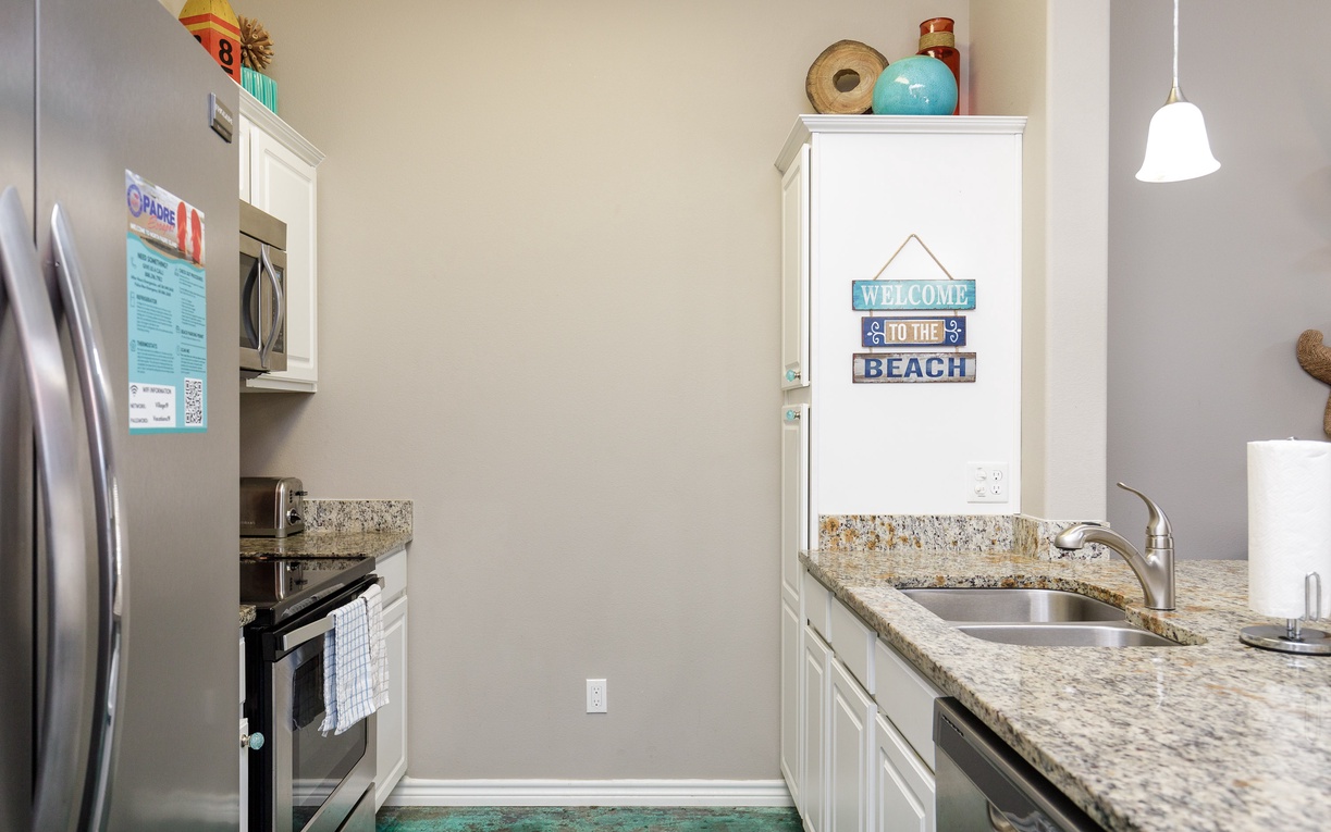 Your fully equipped galley kitchen features granite counters, stainless appliances, and charming coastal touches that make meal prep a breeze.