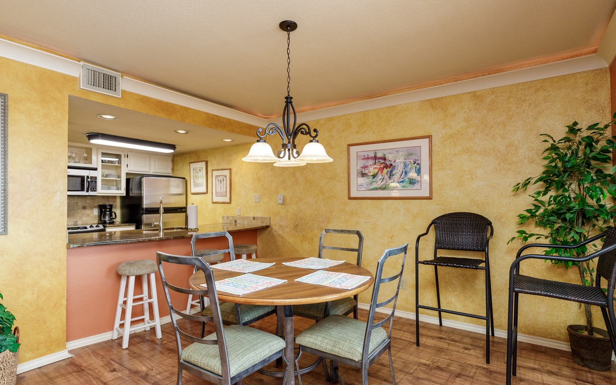Gather around your welcoming dining table where warm lighting and open kitchen create perfect moments for shared meals and conversation.