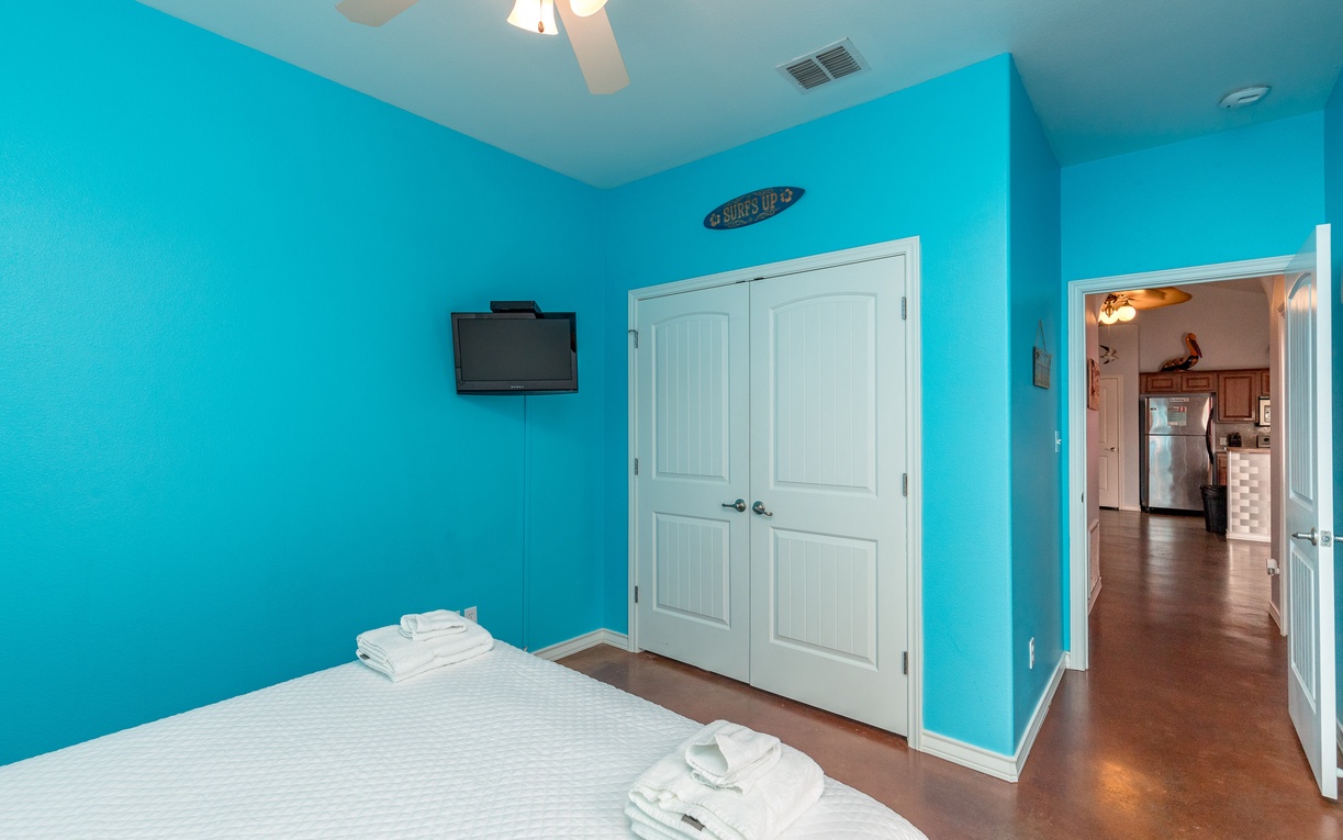 Relax in your vibrant turquoise bedroom where ocean-inspired walls create a coastal retreat. Fresh linens and modern amenities await your arrival.