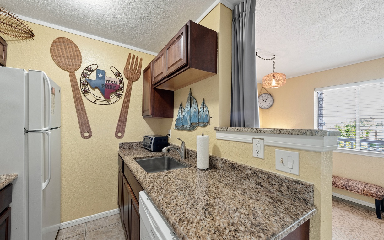 Step into your fully equipped kitchen, complete with granite countertops, rich wood cabinetry, and all the tools you need to whip up your favorite meals or morning coffee.