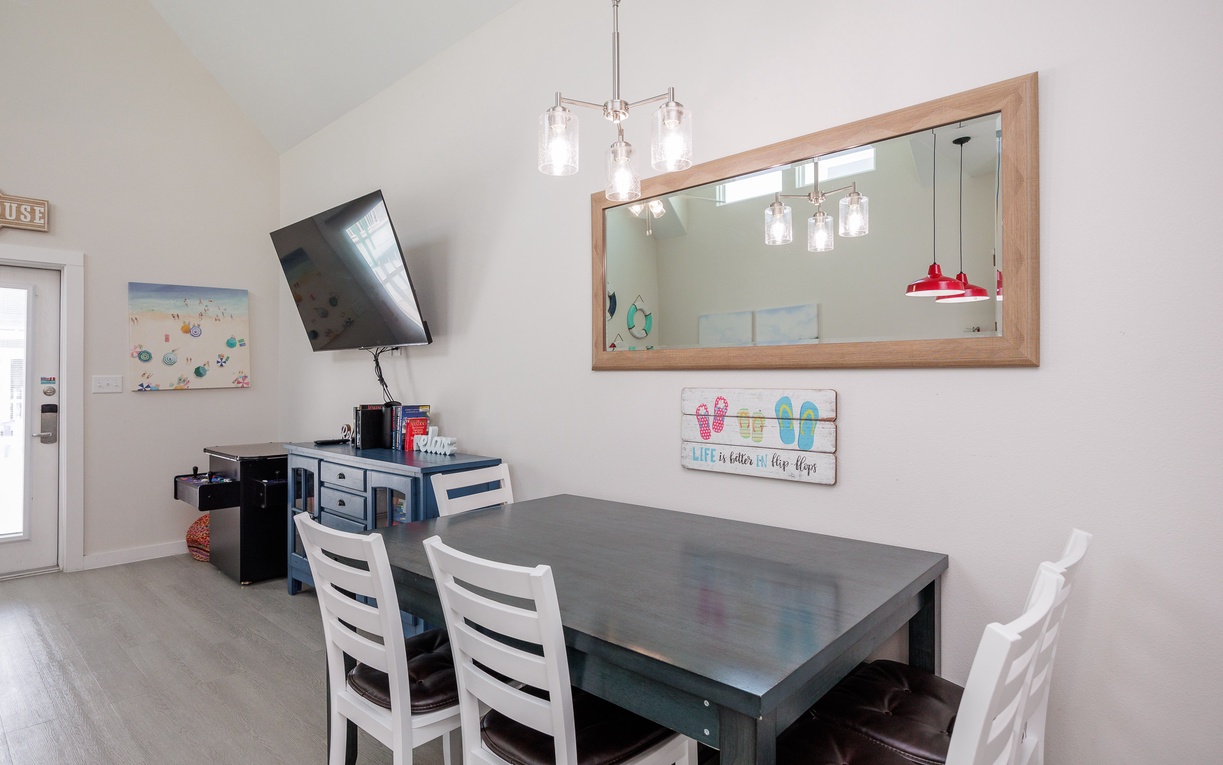 Gather around your dining table for meals and game nights, with a cheerful beach-themed atmosphere and modern pendant lighting creating the perfect ambiance.