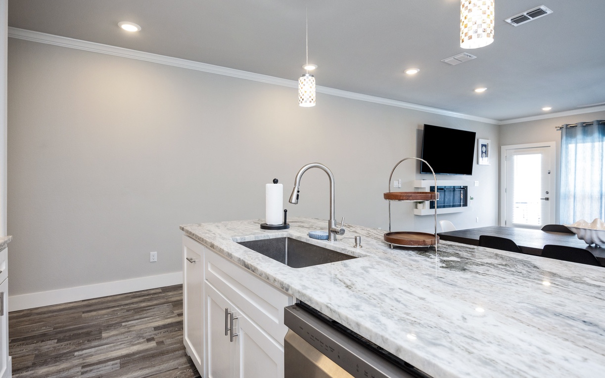 Your modern kitchen features gleaming marble countertops, stainless steel sink, and elegant pendant lighting for memorable meal prep moments.