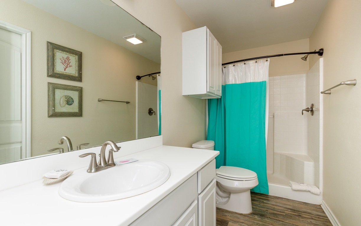 Freshen up in your bright, well-appointed bathroom featuring a spacious vanity, tub-shower combo, and coastal-themed decor that creates a serene retreat.
