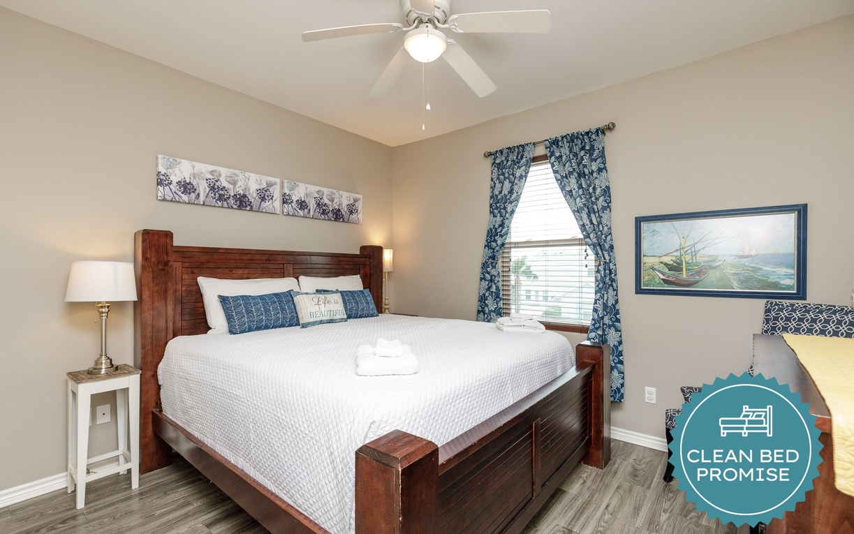 Unwind in your peaceful bedroom featuring a plush bed, gentle ceiling fan, and charming coastal touches that invite restful nights.