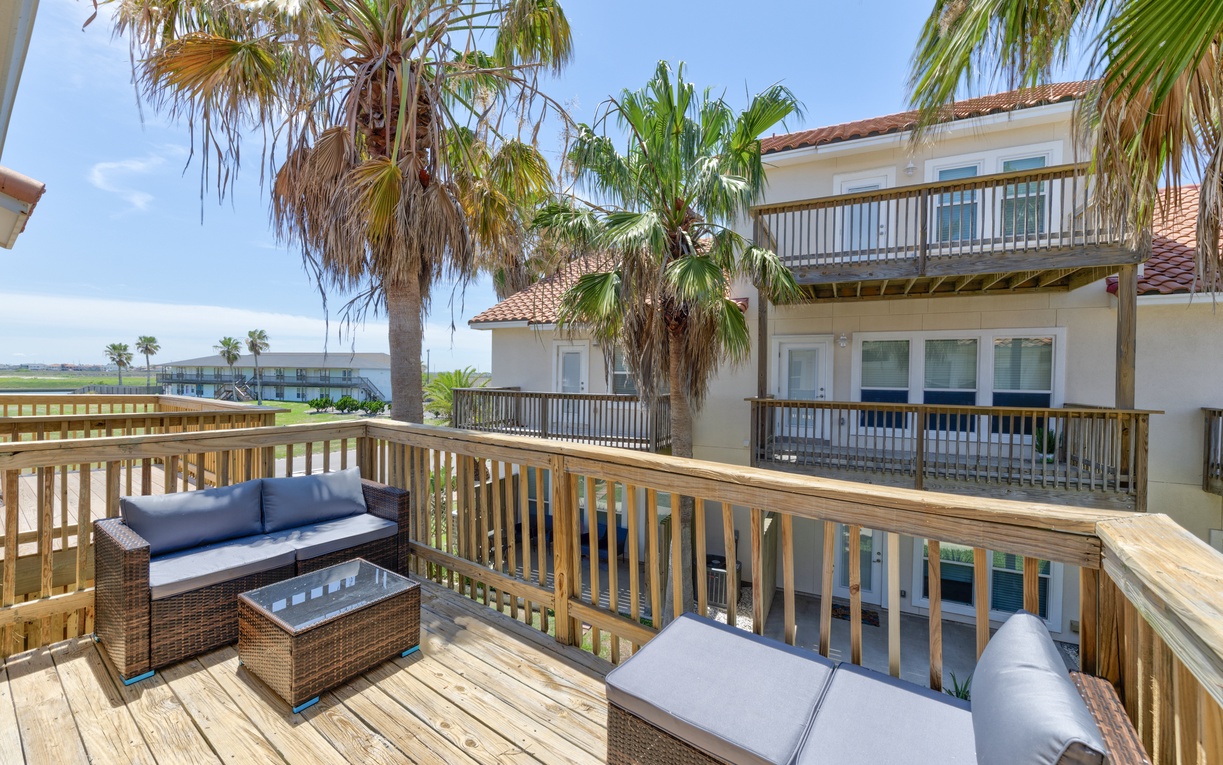 Unwind on this spacious deck with comfortable seating and tropical palm views. The waterfront location and coastal breeze create your perfect seaside escape.