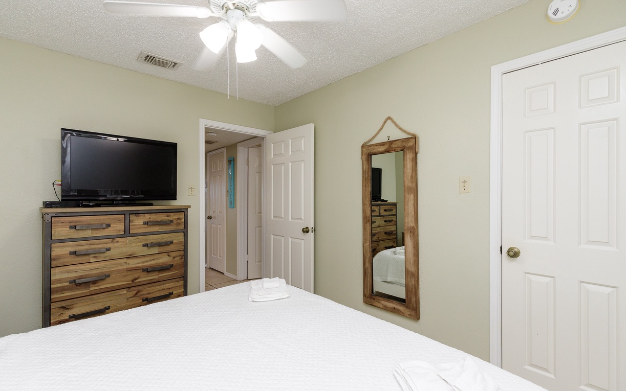 Your cozy bedroom features fresh linens, rustic wood furnishings, and modern conveniences like a flat-screen TV for ultimate relaxation.