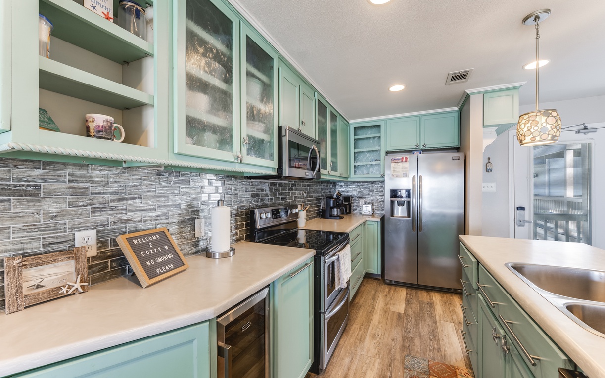 Your fully equipped kitchen features beautiful mint green cabinets, modern appliances, and charming touches that make cooking feel like home.