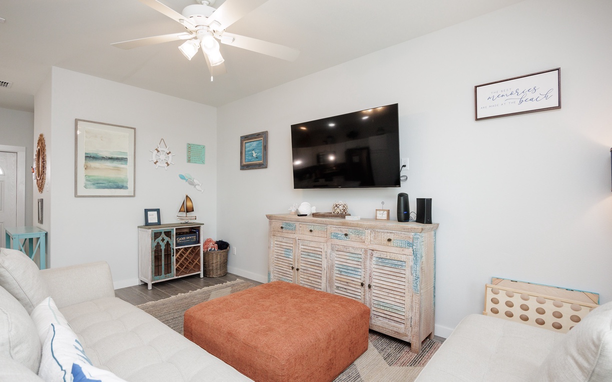Unwind in your coastal-themed living room with plush seating, entertainment center, and charming beachy décor that invites relaxation.