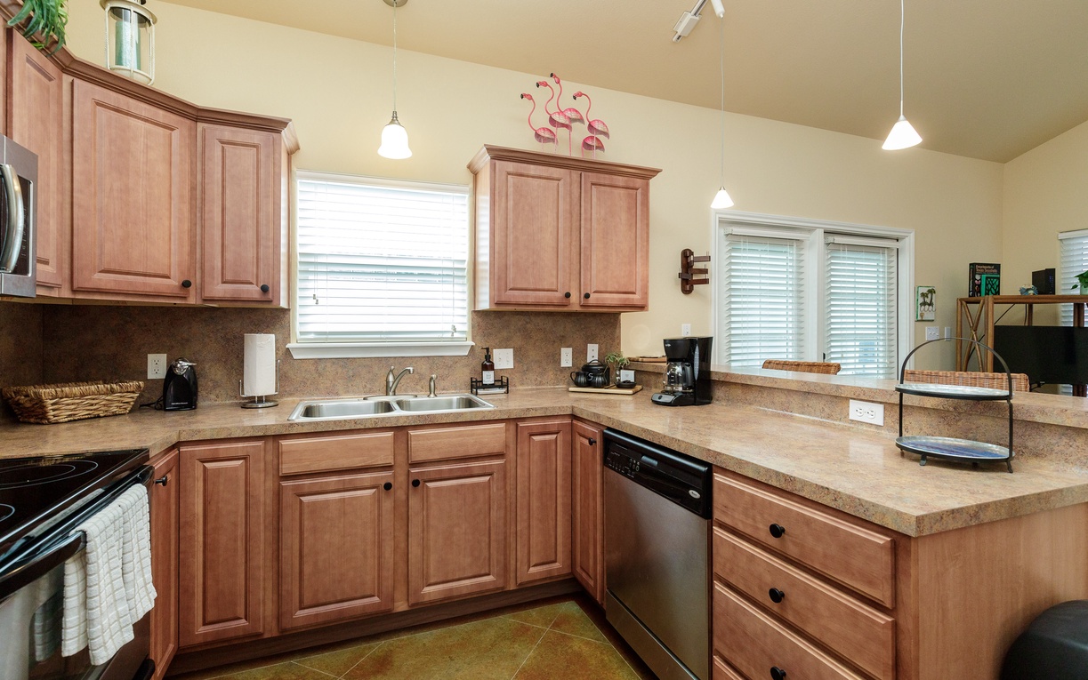 Your fully equipped kitchen features warm wood cabinets, granite counters, and modern appliances—perfect for preparing home-cooked meals during your stay.