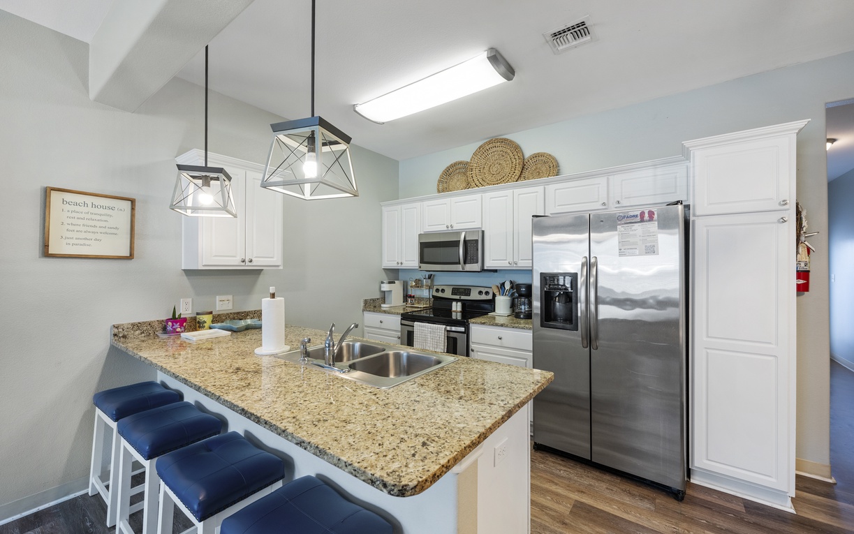 Your fully equipped kitchen awaits with granite counters, stainless appliances, and breakfast bar seating for casual meals and morning coffee.