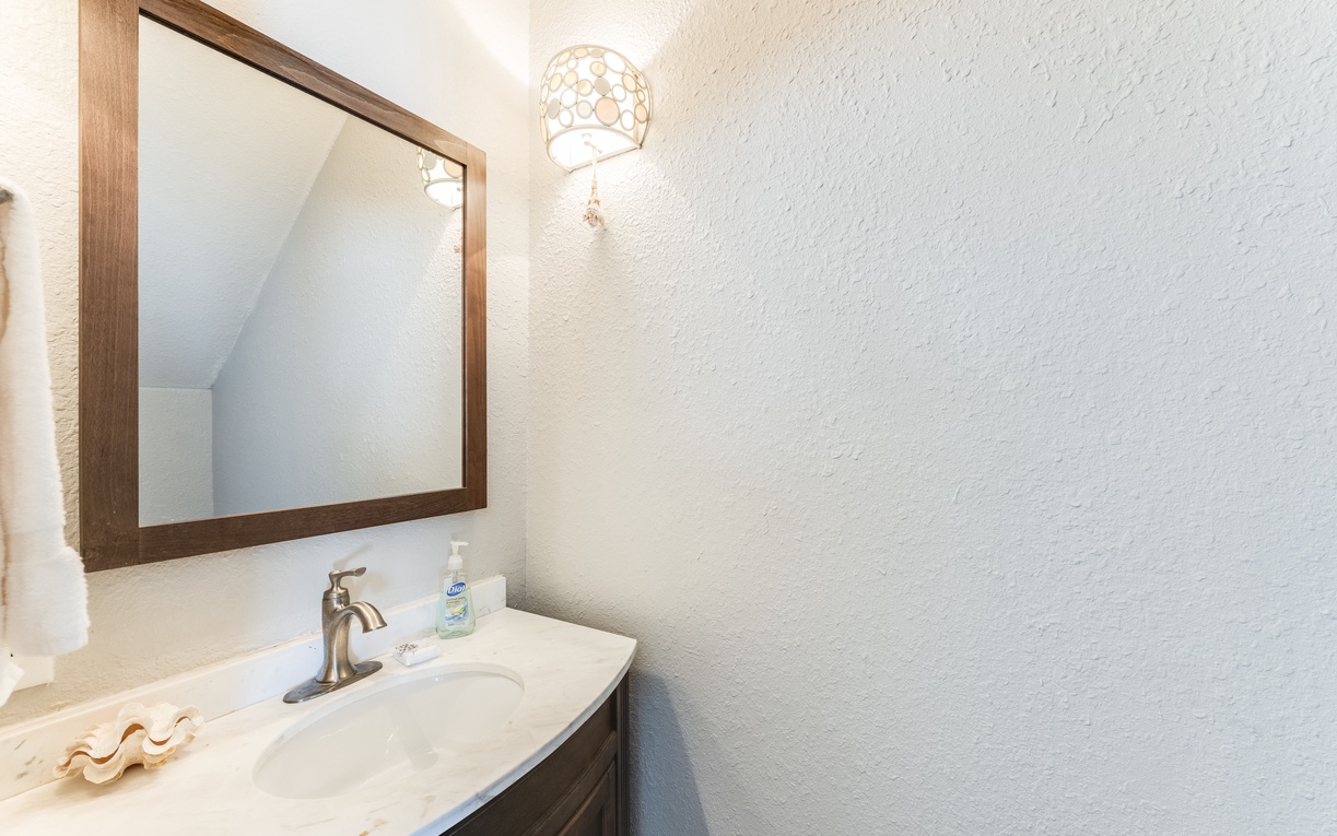 Freshen up in your stylish powder room with elegant lighting and modern fixtures for your comfort.