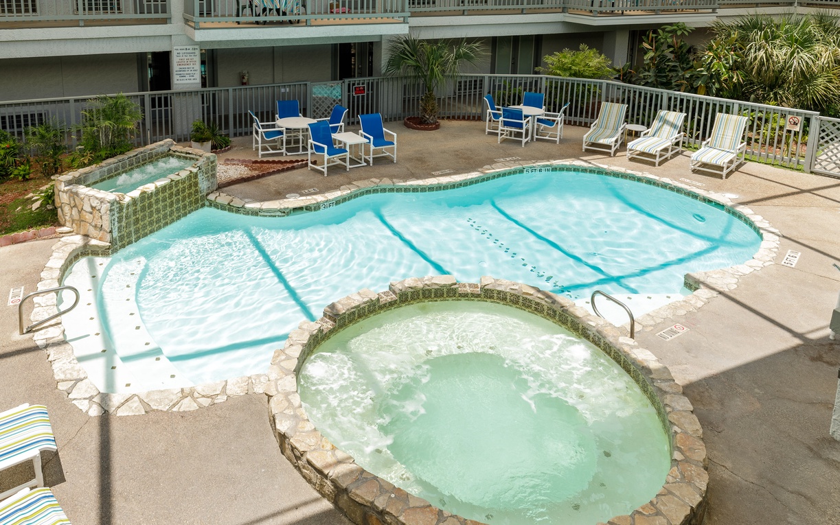 Soak in the sparkling pool or unwind in the bubbling hot tub, surrounded by comfortable lounge chairs for your perfect day of relaxation.