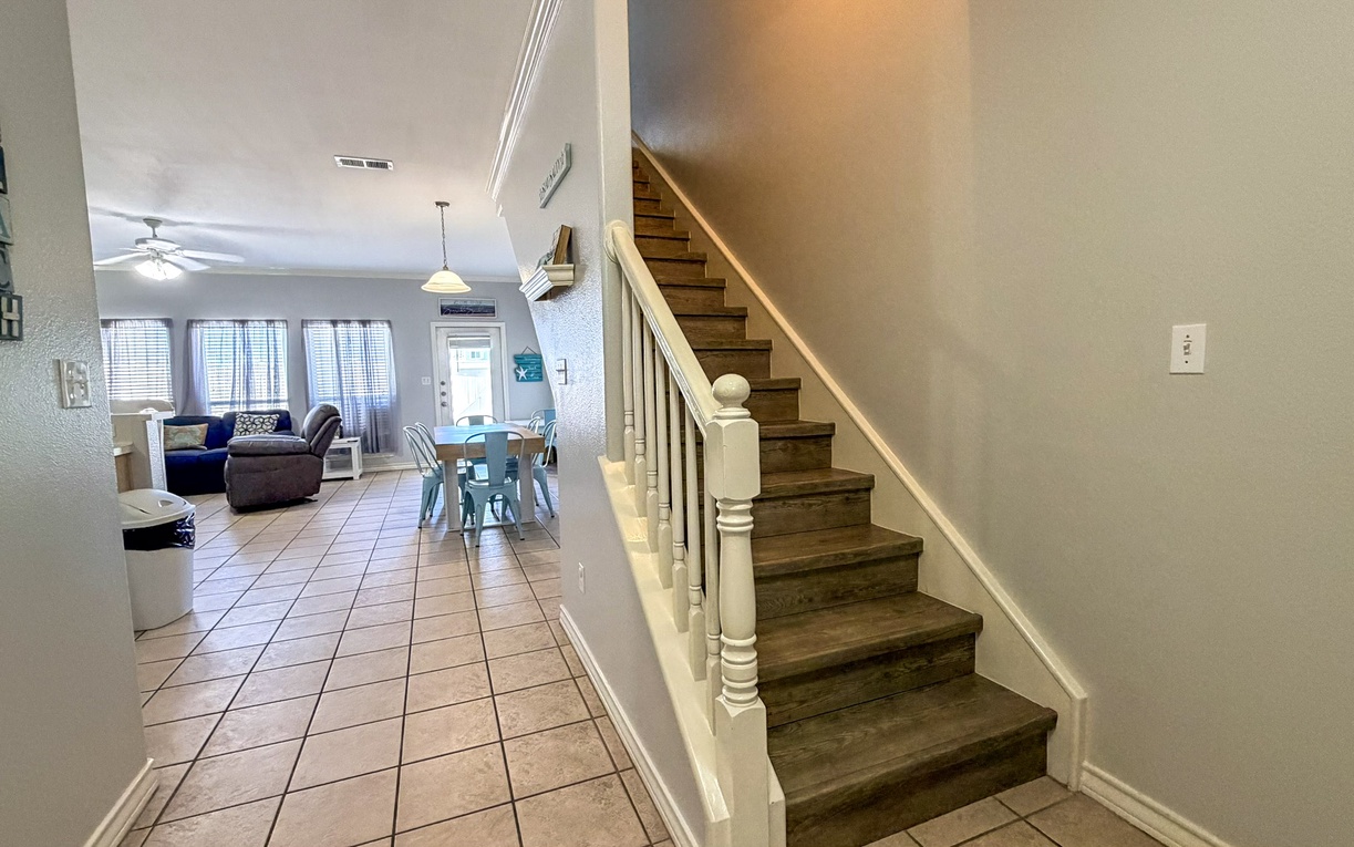 Step into your bright, open living space where coastal blues and comfortable seating invite you to unwind after beach days.