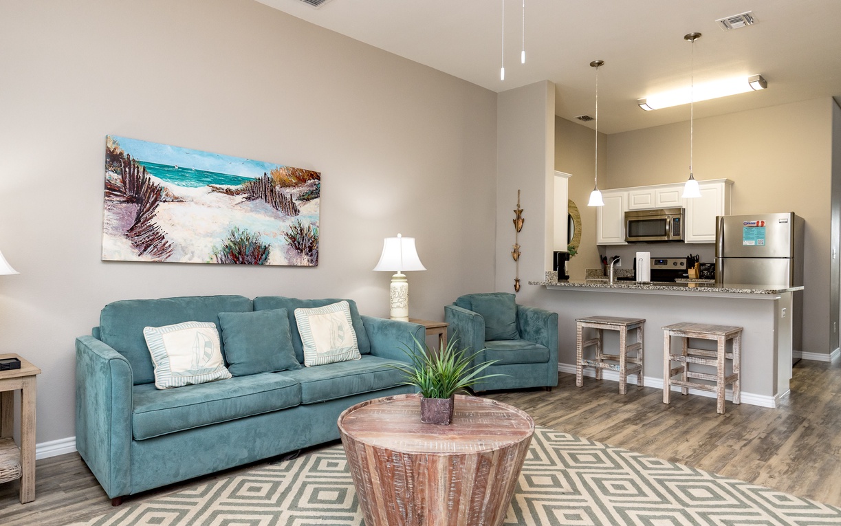 Unwind in your stylish open-concept living space with coastal charm, complete with a full kitchen and comfortable seating for memorable evenings together.