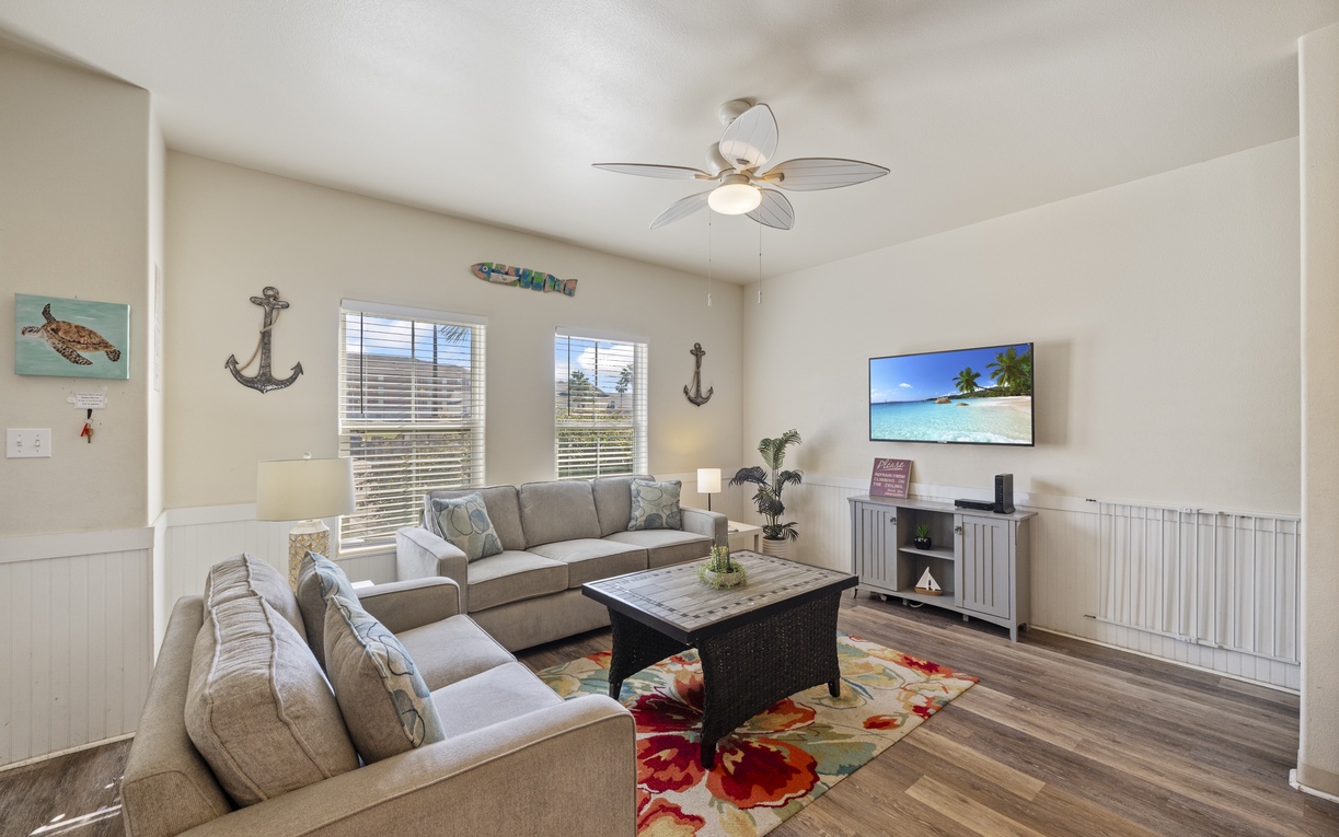 Sink into the plush sectional sofa while ocean breezes from the ceiling fan keep you cool in this cheerful coastal living room.