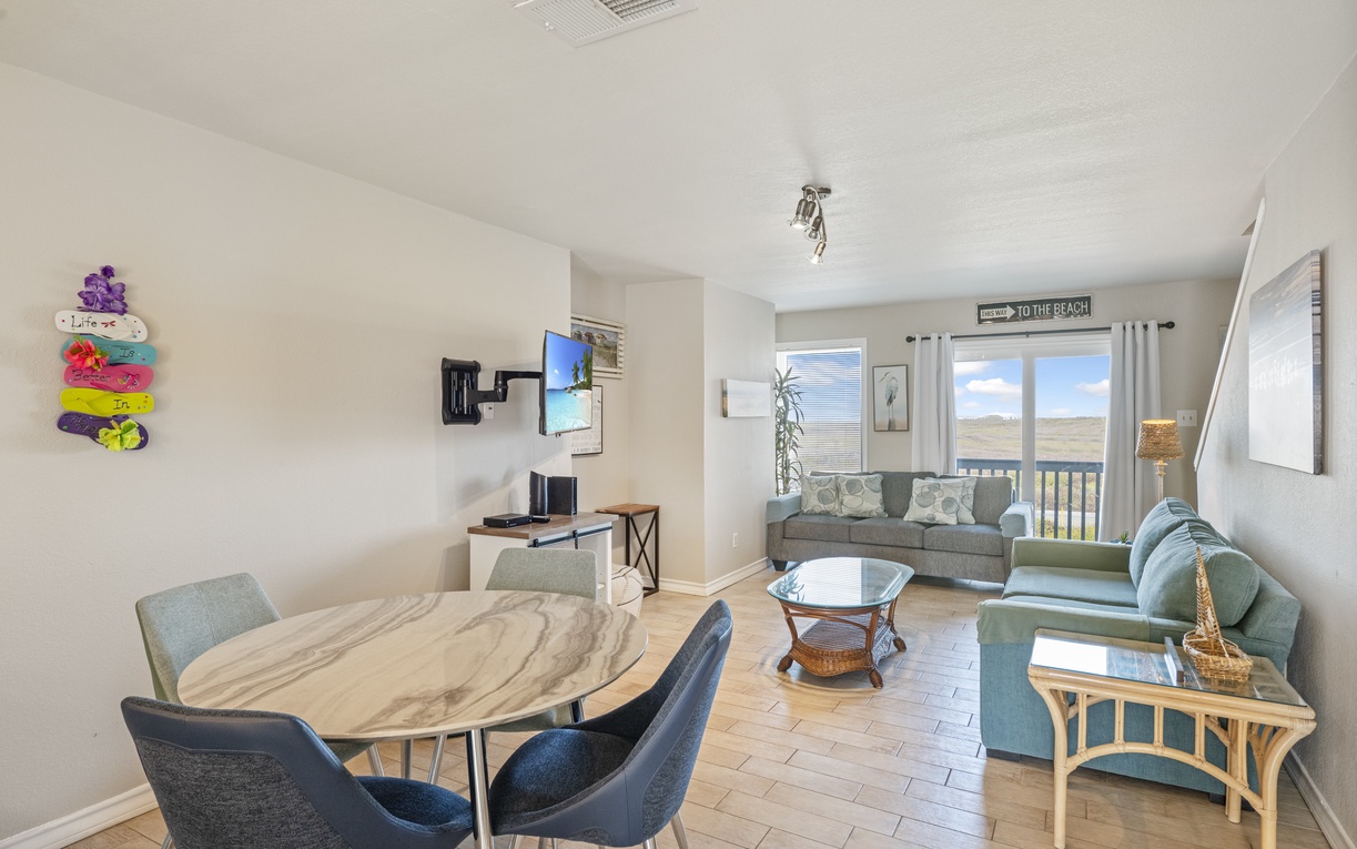 Settle into your bright, open living space where coastal decor meets modern comfort. Natural light streams through while you relax on plush seating or gather around the dining table.