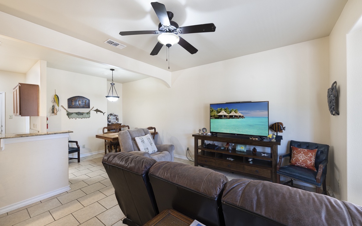 Relax on the plush leather sofas in your living room, where the ceiling fan keeps you cool as you enjoy your favorite shows on the big screen TV.