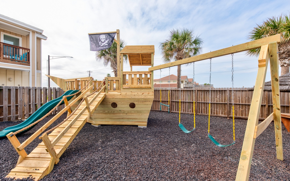 Your little ones will love the pirate ship playground with slide and swings in this safe, enclosed backyard.