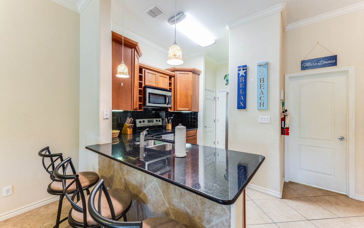 You'll love preparing meals in this bright kitchen with granite counters, warm wood cabinets, and breakfast bar seating for casual dining.