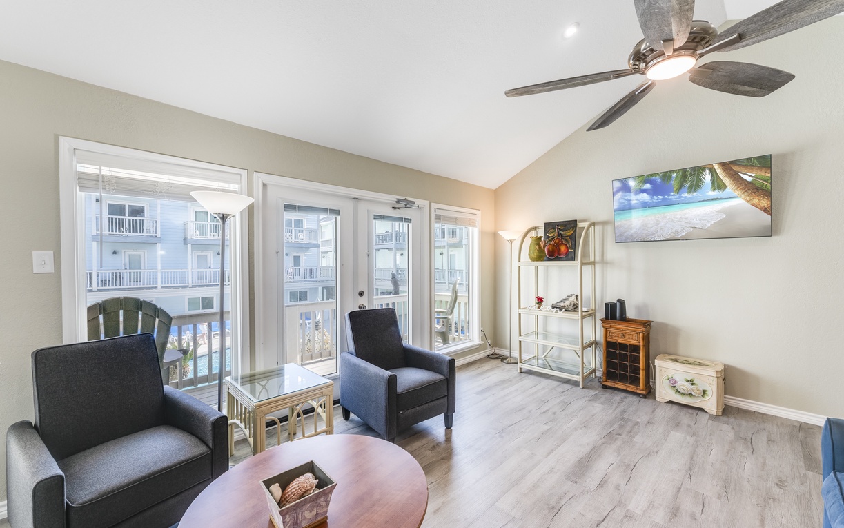Unwind in your bright living room with coastal views through floor-to-ceiling windows and sliding doors opening to your private balcony.