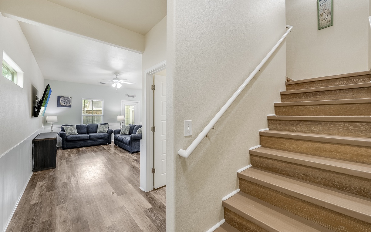 Your bright living room flows seamlessly with modern wood stairs, creating an open space for relaxation and connection.