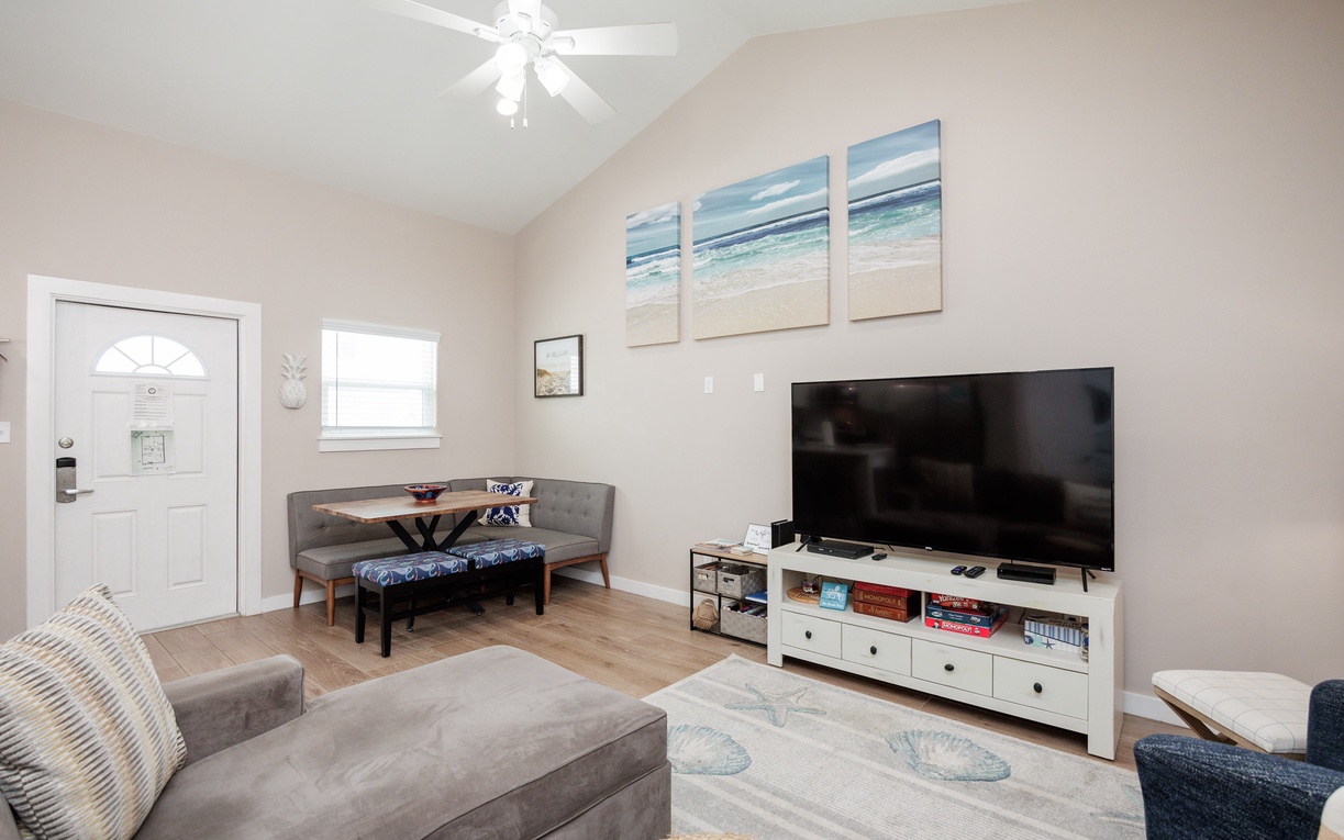 Relax in your bright living space with plush seating, coastal artwork, and entertainment center for cozy evenings together.