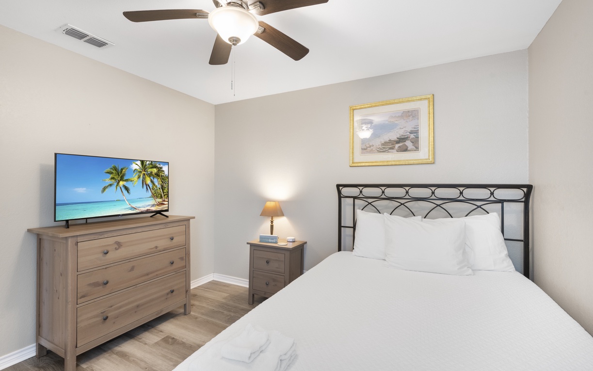 Your peaceful bedroom features a comfortable bed, ceiling fan for cool nights, and TV for relaxation after your adventures.