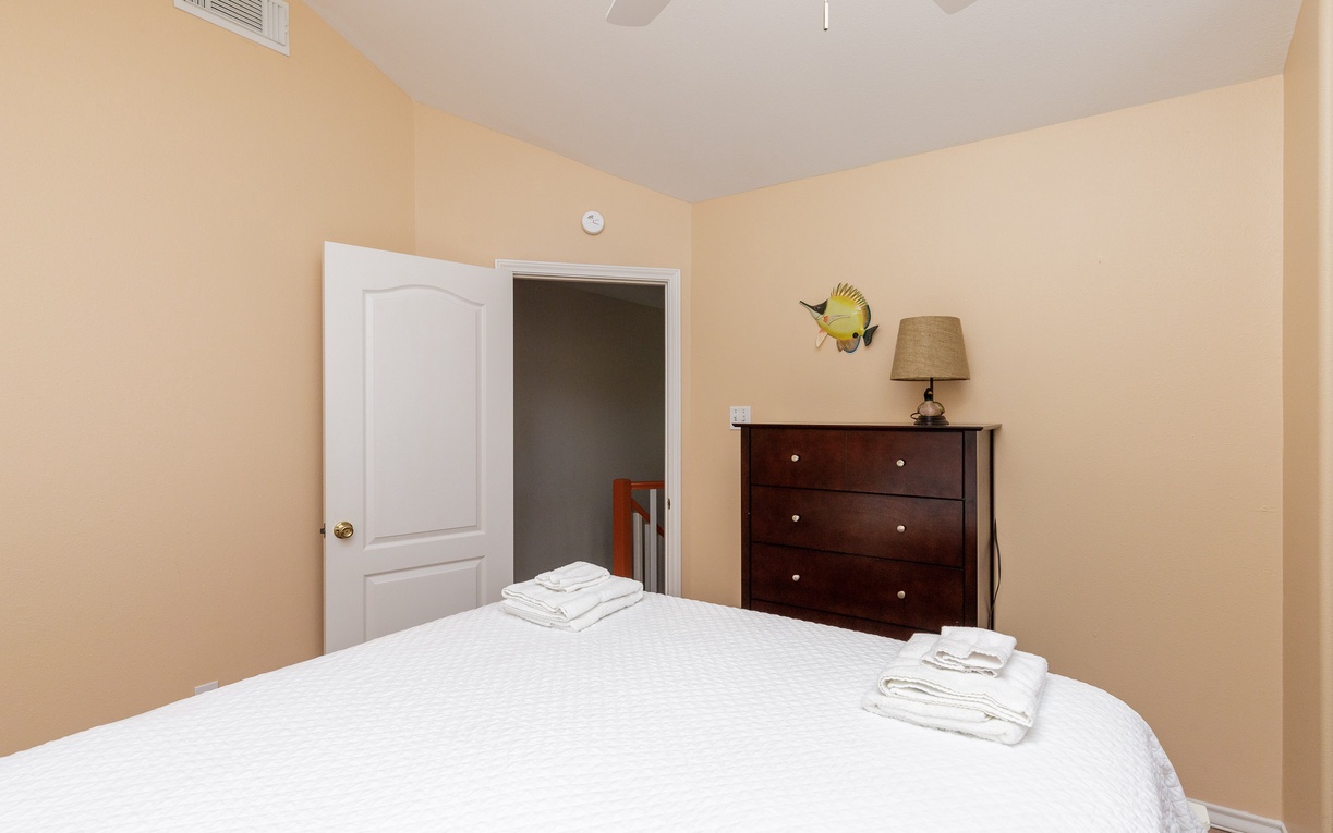 Cozy bedroom with comfortable bedding, warm lighting, and thoughtful touches like fresh towels waiting for your arrival.