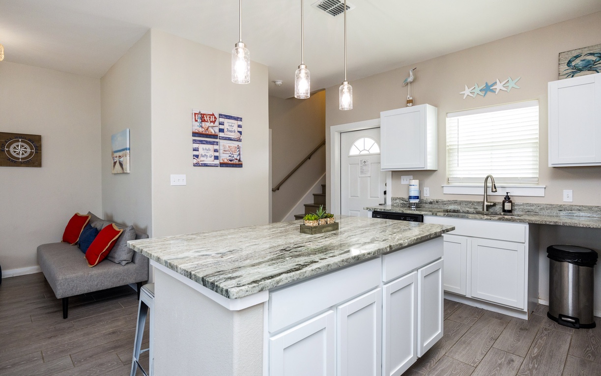 Your open-concept kitchen features beautiful granite countertops and modern white cabinets, perfect for preparing meals while staying connected with family and friends.