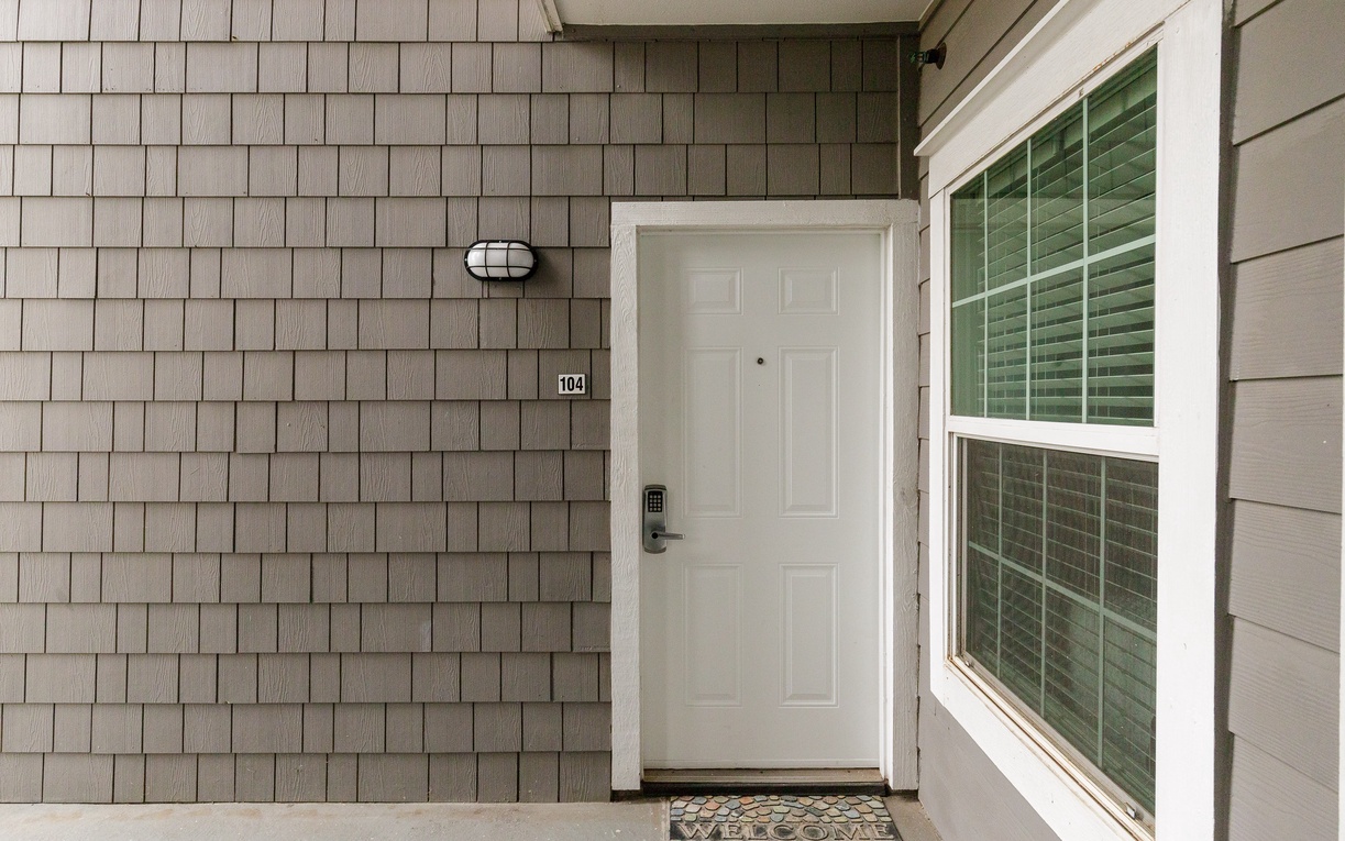 Charming entrance with cedar shingle siding and covered entry for a welcoming arrival experience.